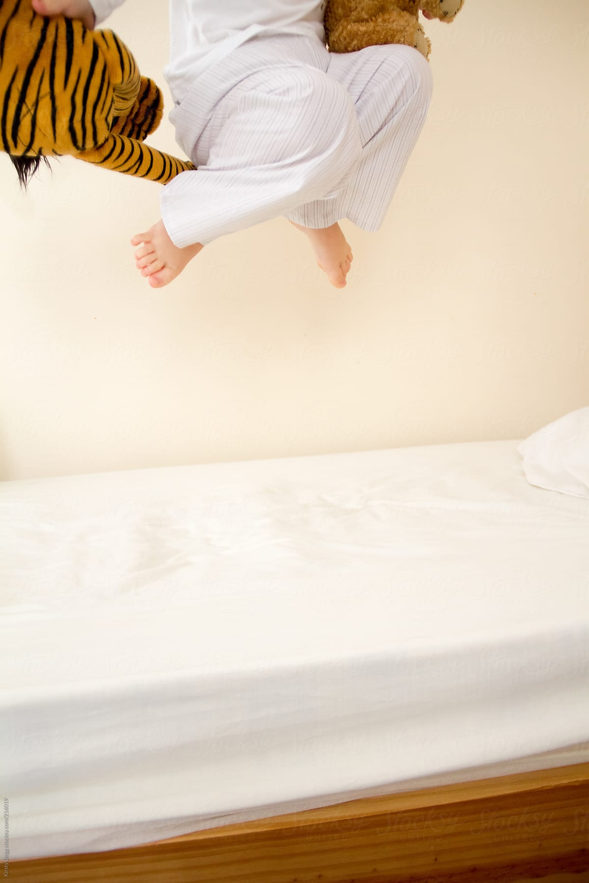 Little Boy in pajamas jumps on bed