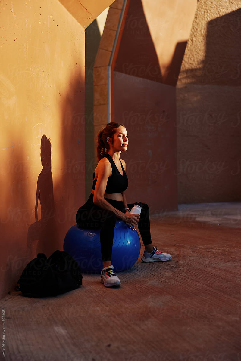 Pregnant female athlete sitting on fit ball