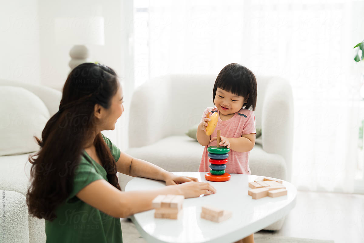 Mother and daughter playing wood block tower stacking game