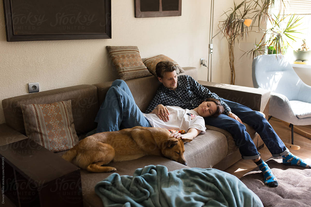 a man with a girl and a dog on the couch