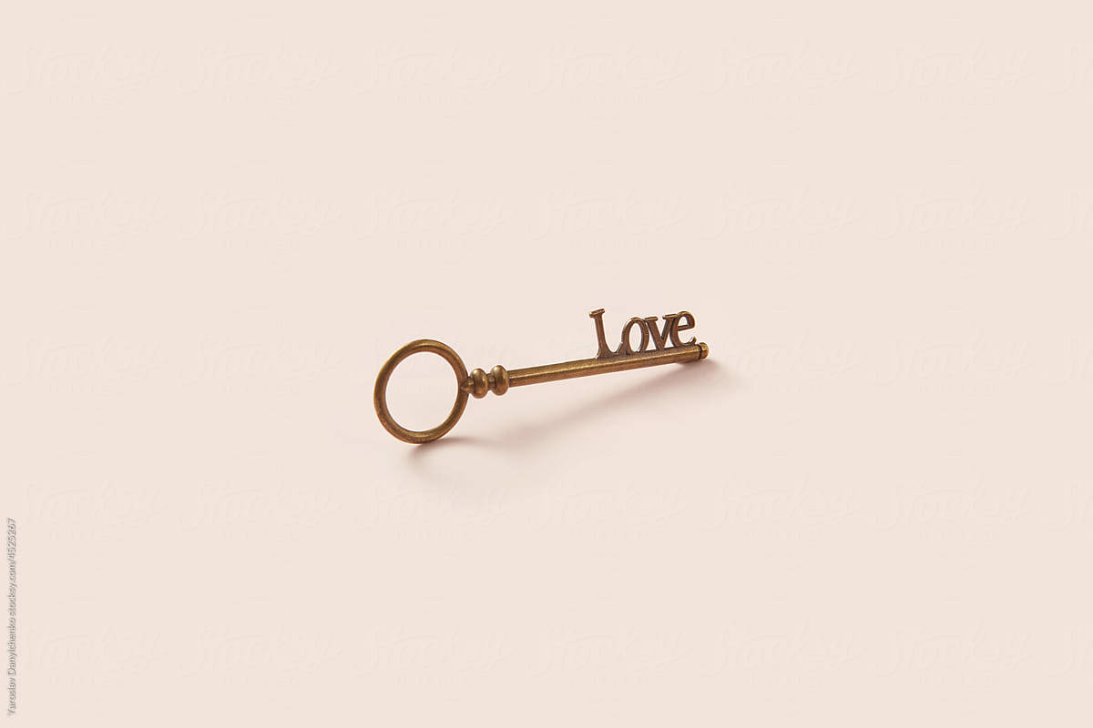 Old vintage key with love word on beige background