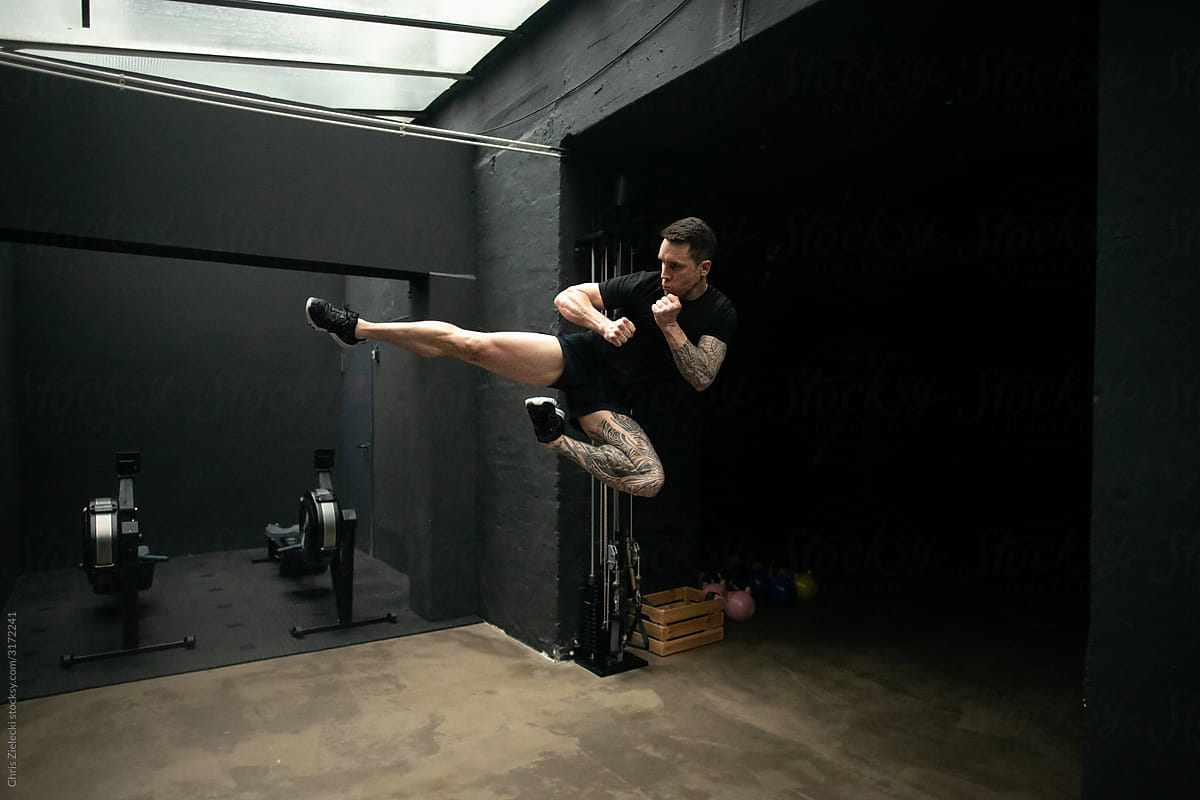 Kickboxer jumping during training in gym