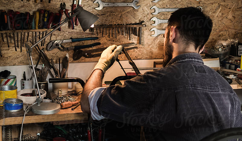 Young mechanic working on bike maintenance in his  rustic workshop.