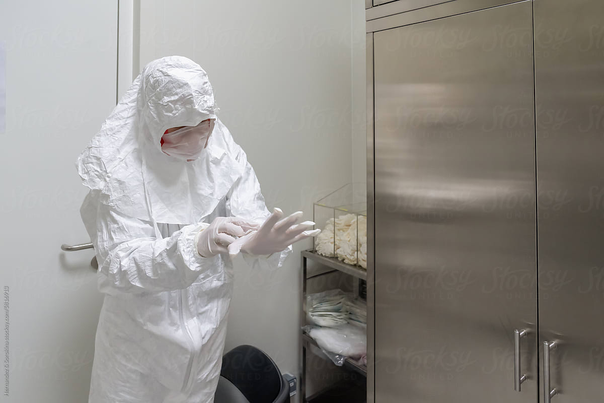 Researcher Putting Safety Clothing And Gloves
