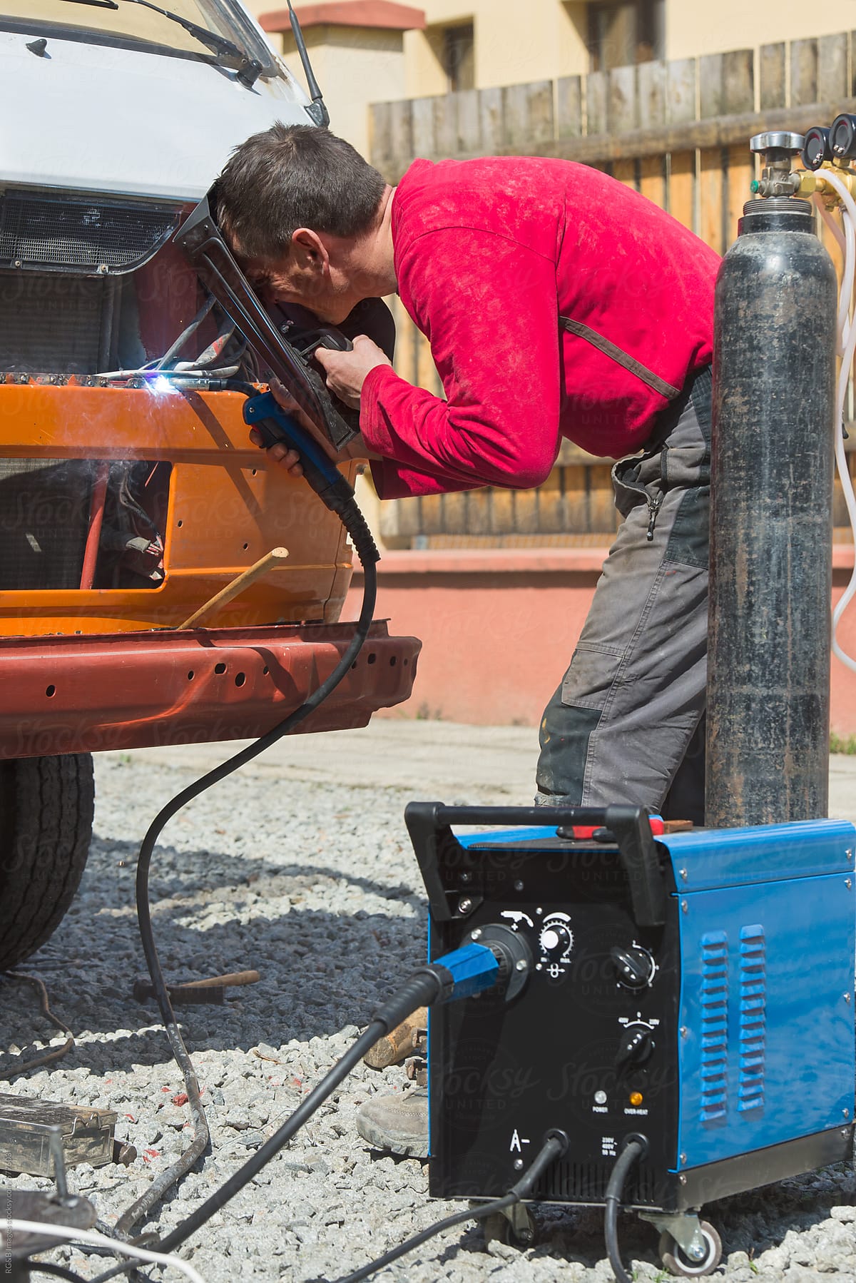 Man using metal  welding in a car restoration process