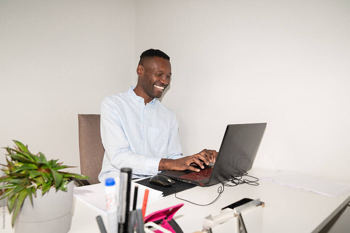 Smiling Black Man Using Laptop