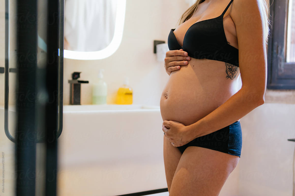 Pregnant Woman In Panties Touching Belly by Stocksy Contributor