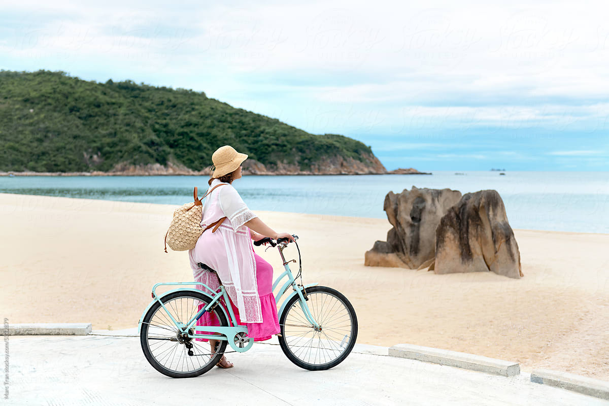 Curvy Woman on a bicycle ride along The Beach