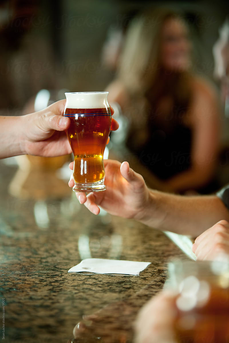 Bar: Bartender Hands Beer To Fellow