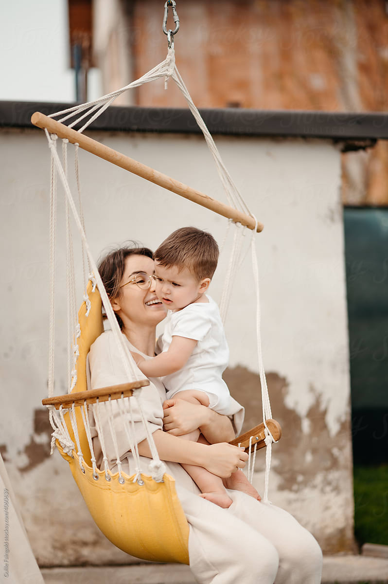 Mother with toddler on swing.