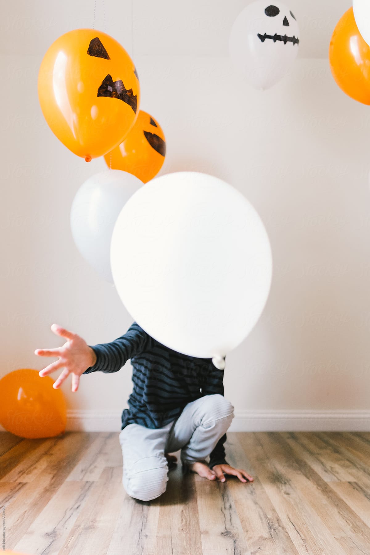 young boy plays with balloons