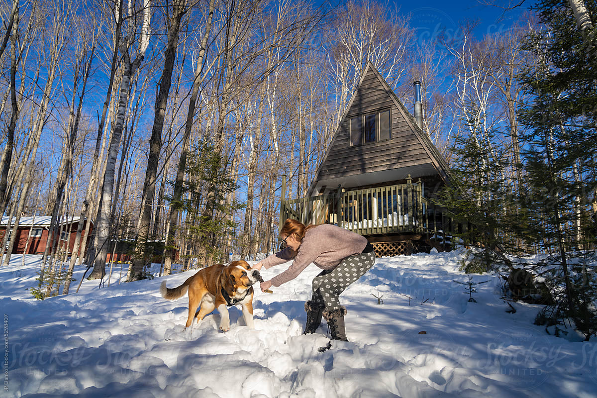 Woman Playing WIth Big Dog at Winter Cottage