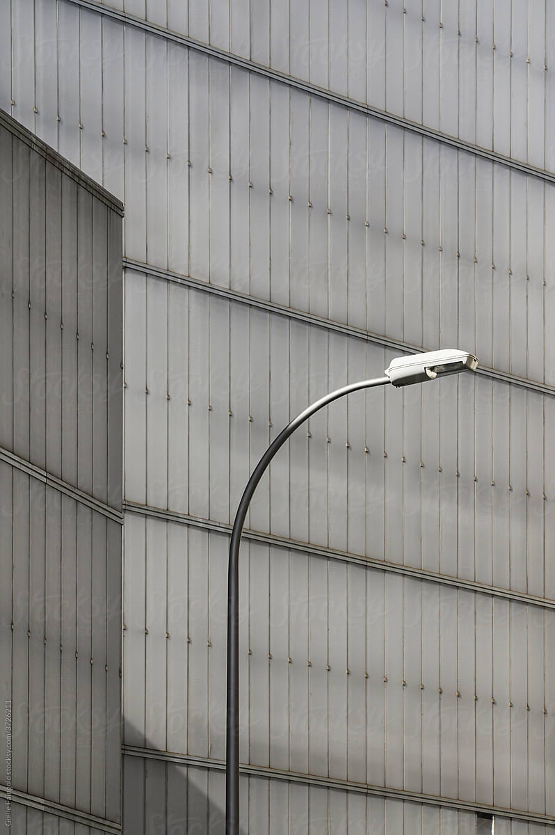Gray walls of building and one street lamp.