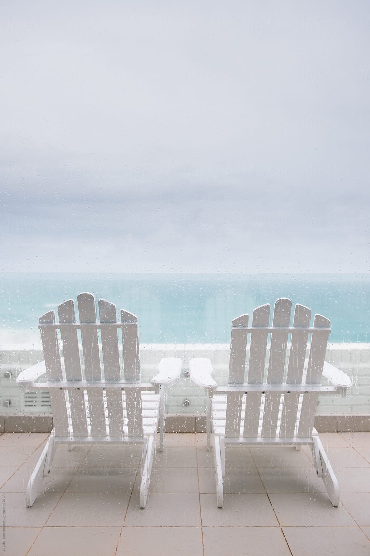 Forlorn chairs on a balcony during a storm
