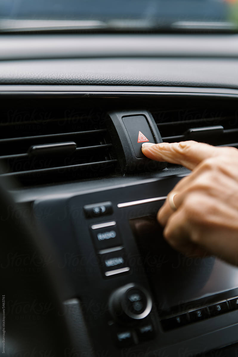 close up of finger pushing button in car