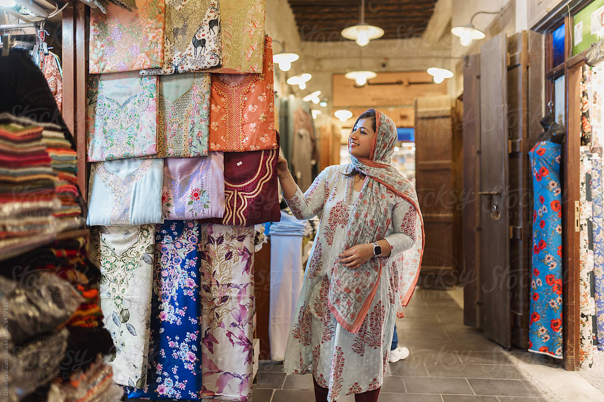 Muslim female buyer choosing wear at market