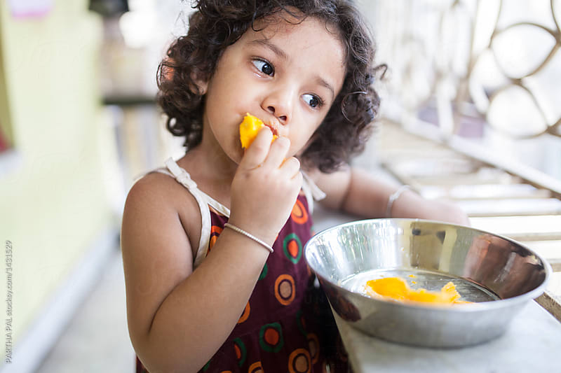 Kid enjoy eating mango in summer