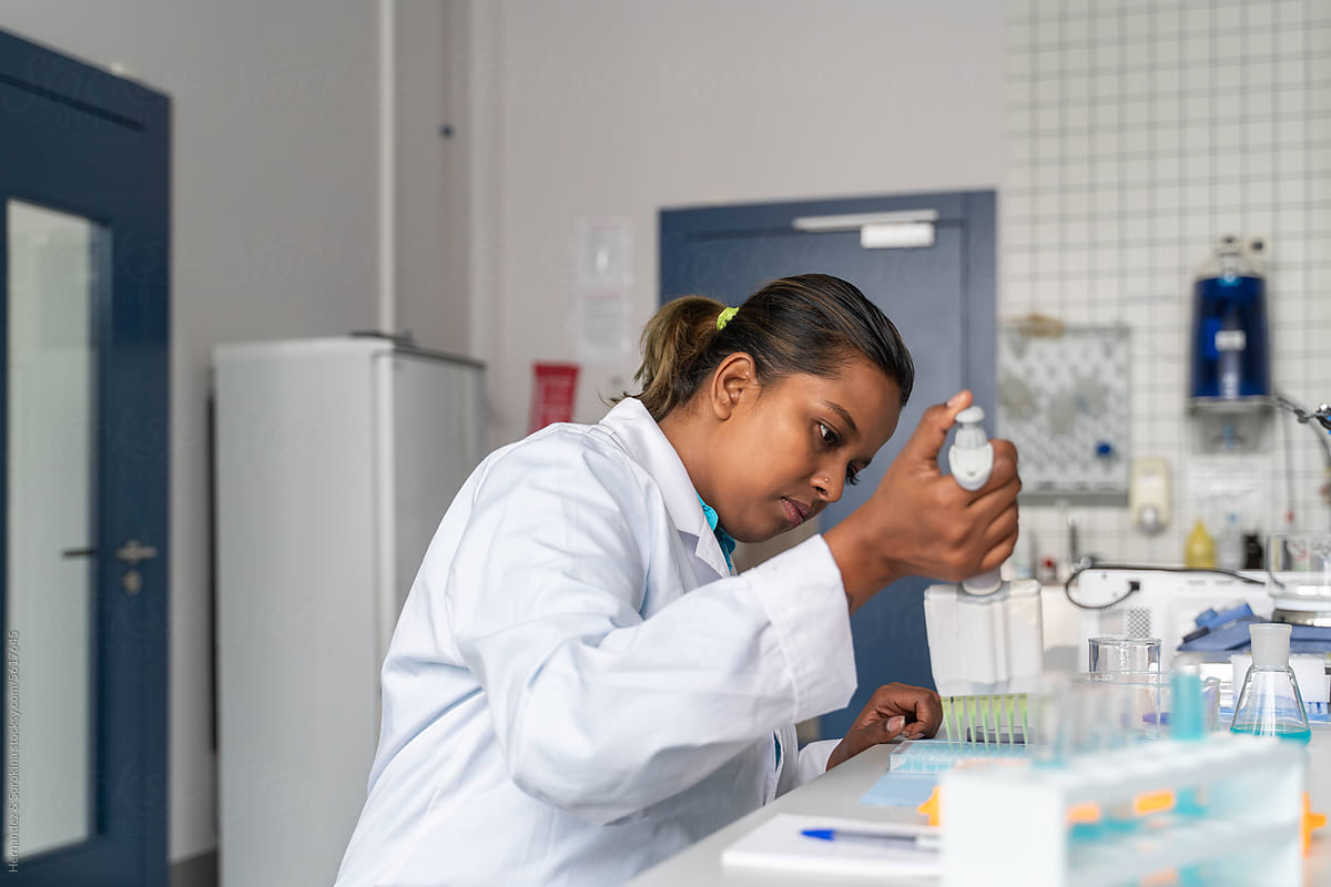 Black Scientist Using Pipette In Lab
