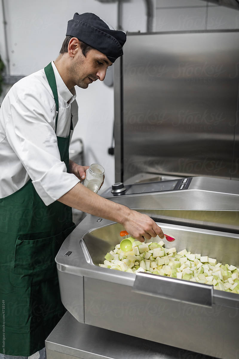 chef cooking vegetables in the industrial fryer in a kitchen