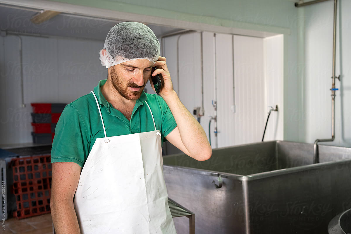 Worker With Phone In The Cheese Factory.
