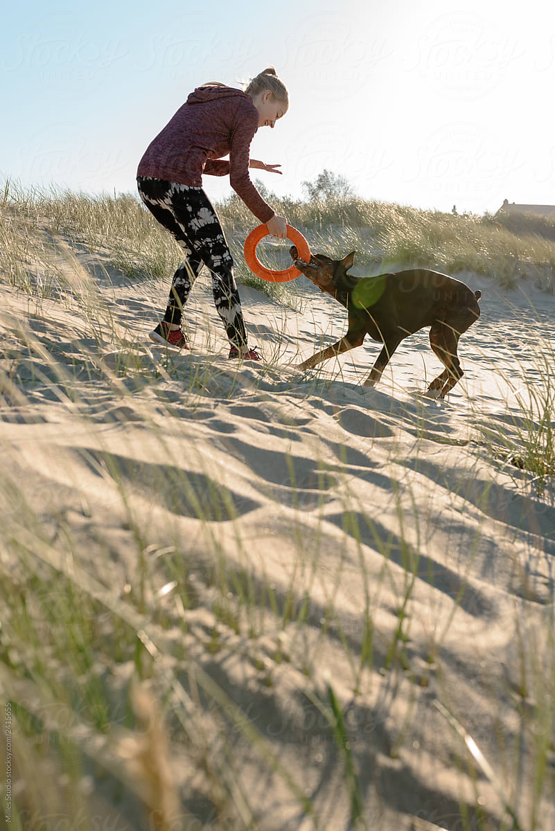 Girl with dog having on seashore