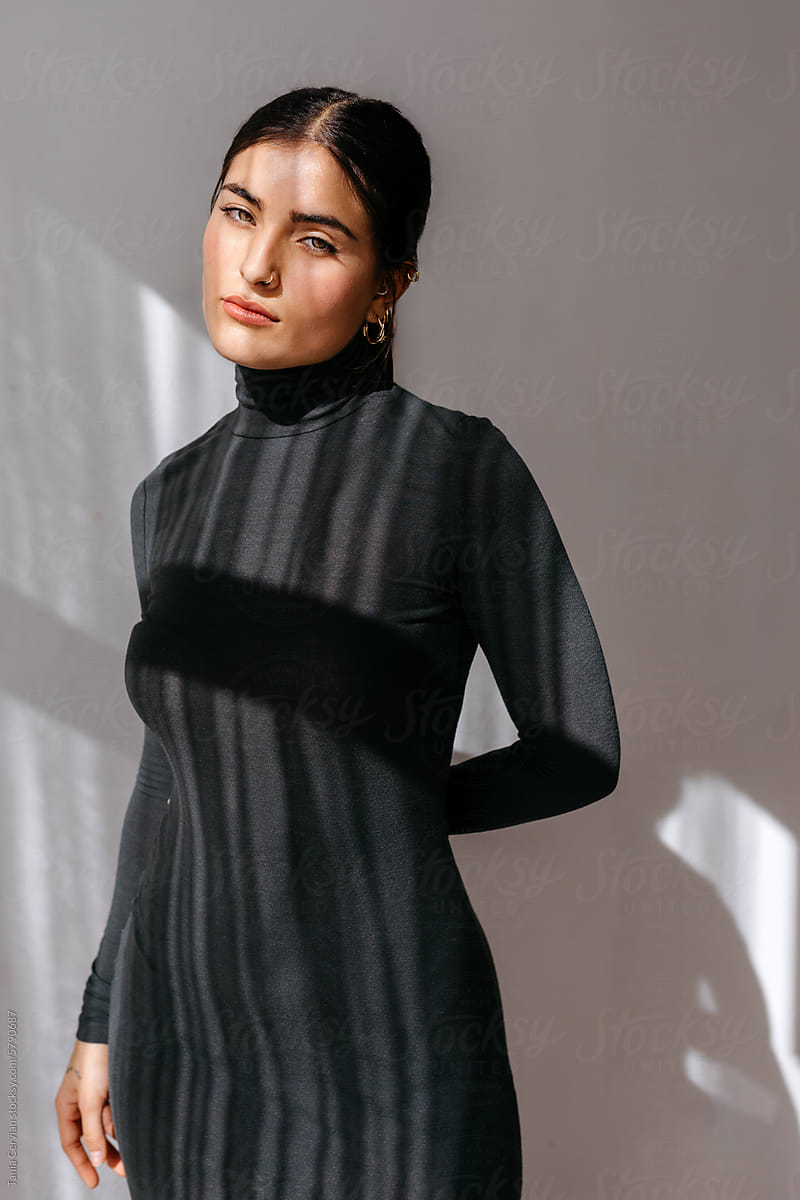 Stylish lady in black turtleneck dress in studio