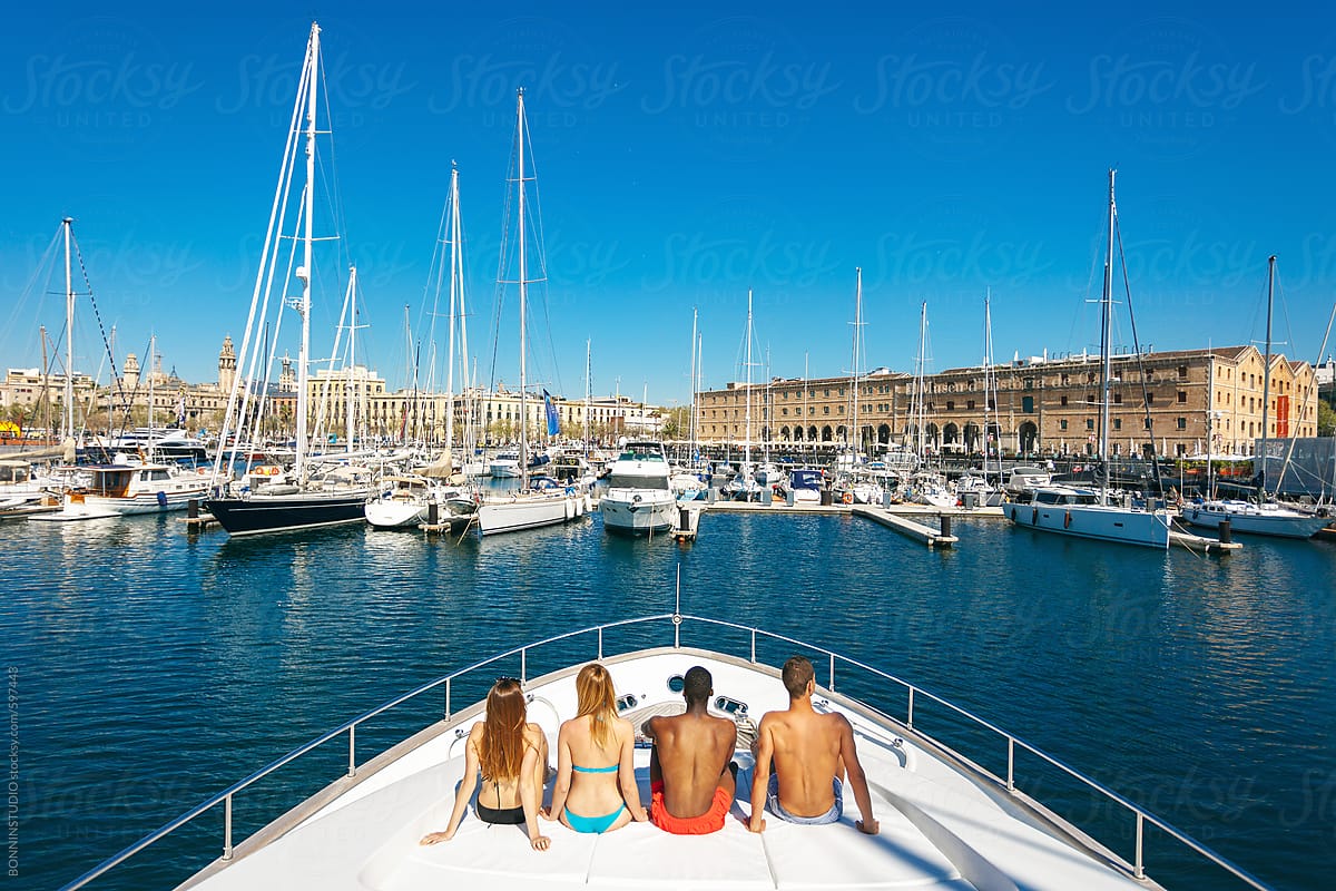 Back view of a group of friends tanning on a luxurious yacht.