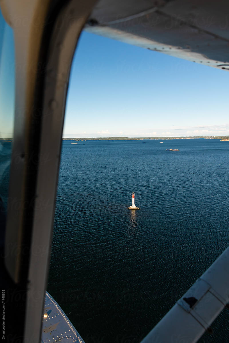 Float Plane Flying Over Lighthouse