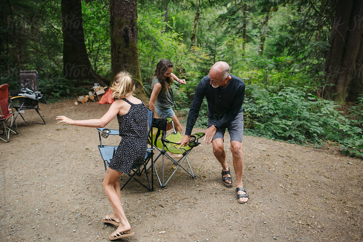 Fun loving grandpa playing musical chairs with grandkids on camp