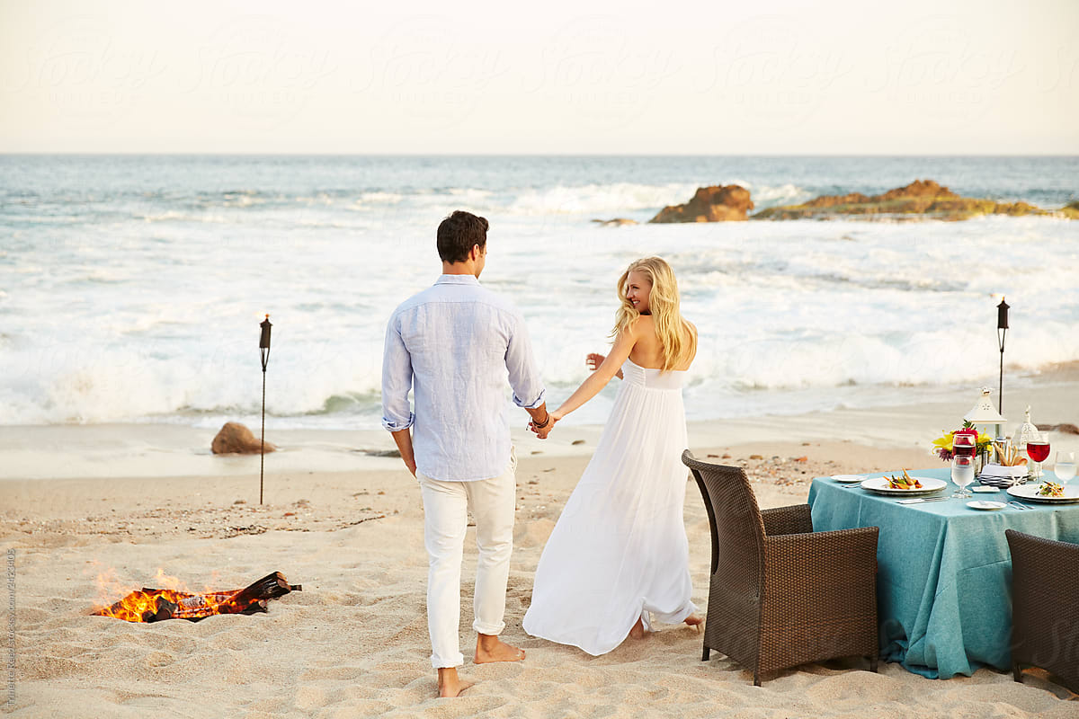 Couple walking to a romantic dinner on the beach