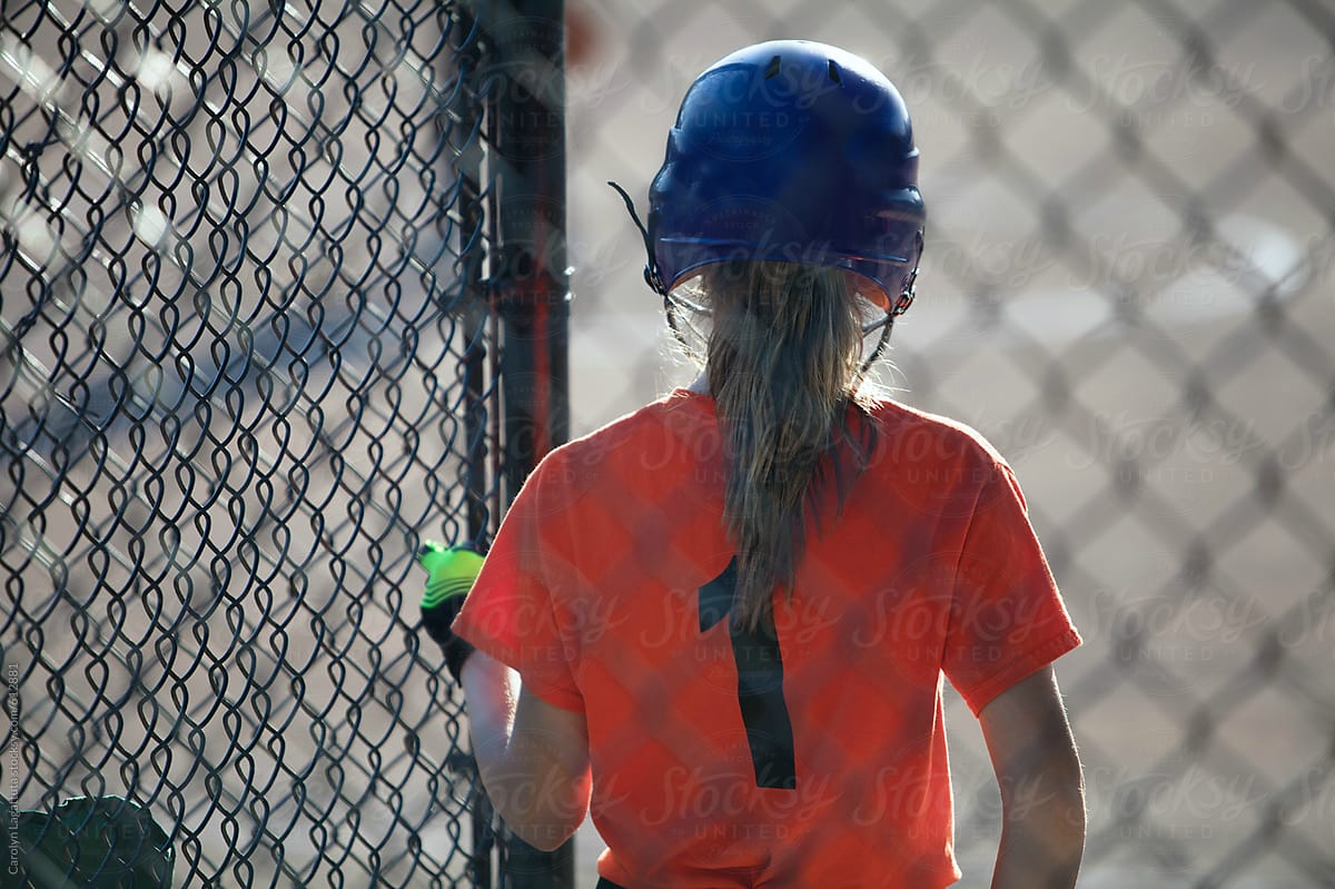 Teenage girl waiting for her turn at bat on the softball field