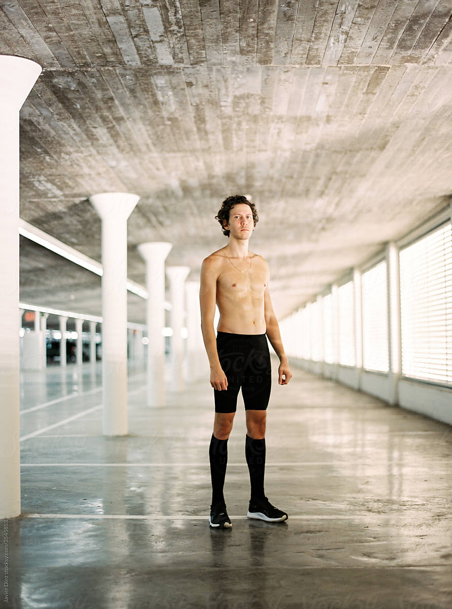 Shirtless sportsman standing in passage