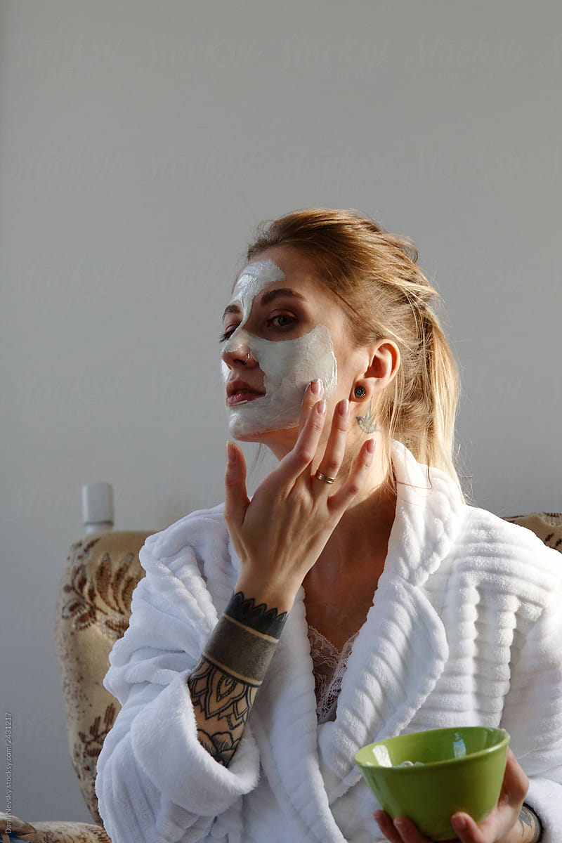 Woman smearing mask on face