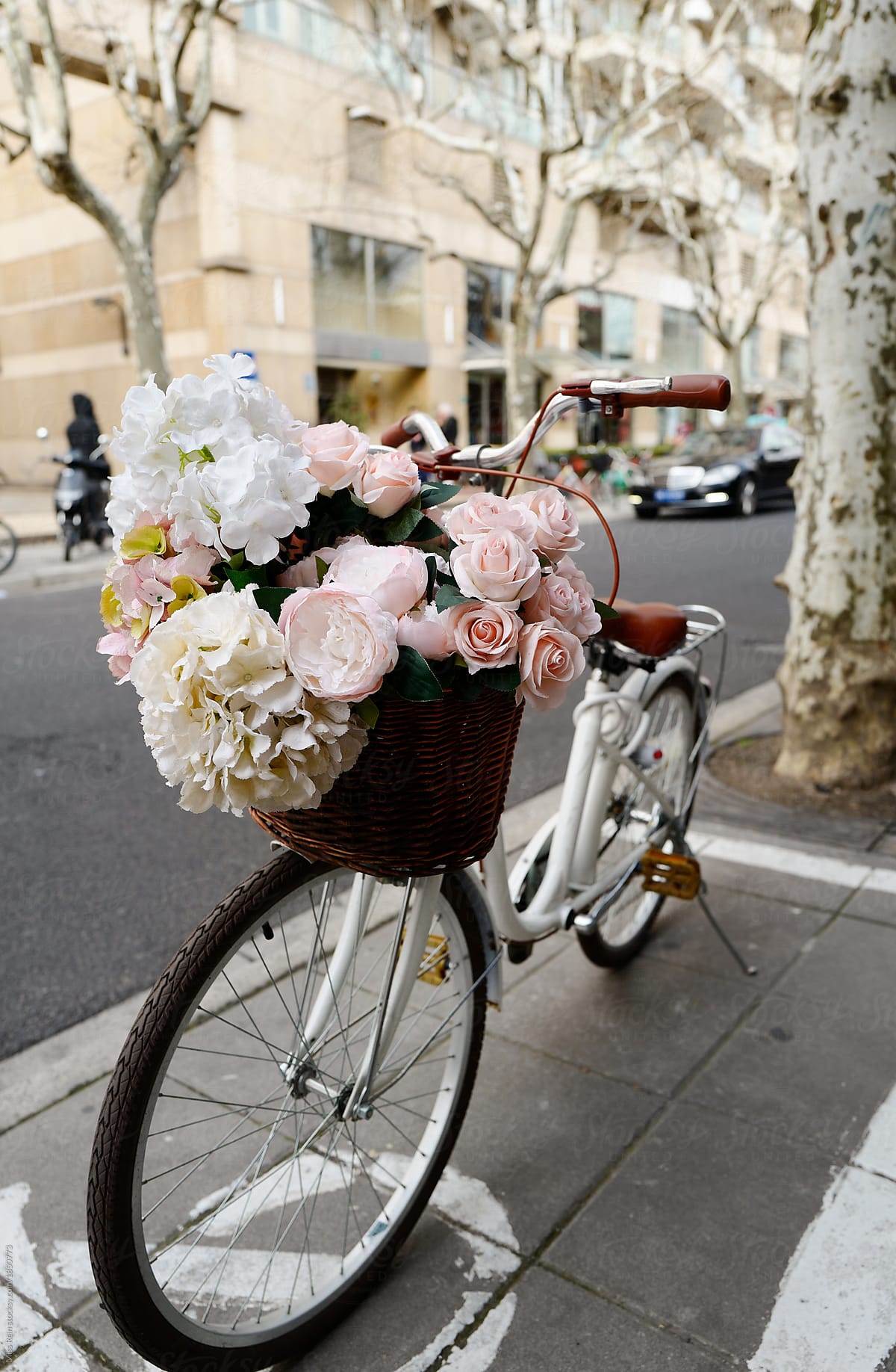 White bike filled with flowers in the basket