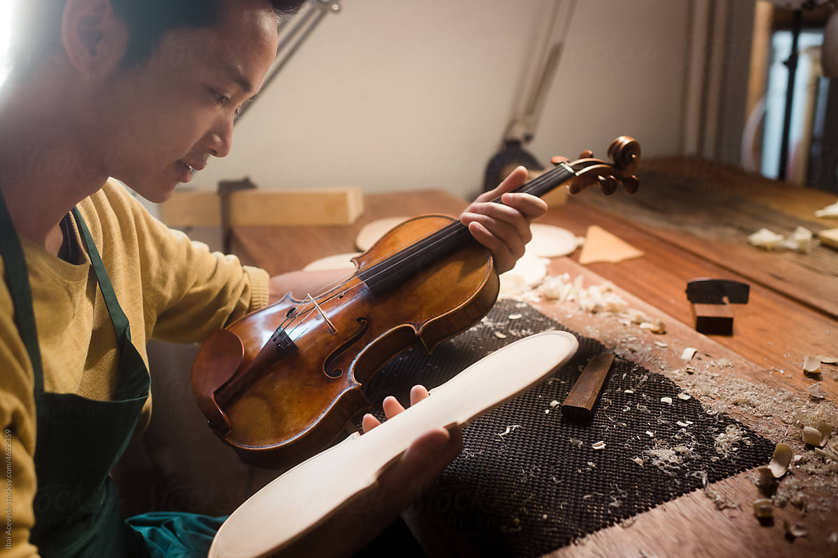 Young luthier creating a violin