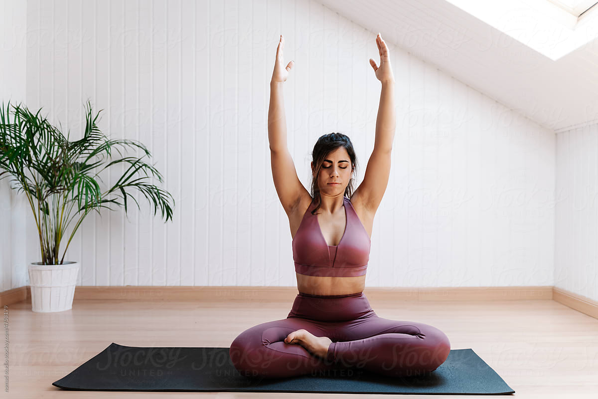 Young woman practicing yoga exercise at home
