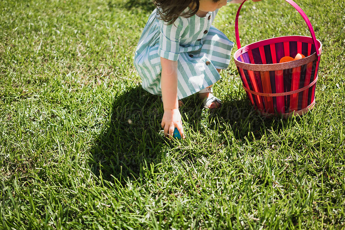 Little girl finding Easter eggs.
