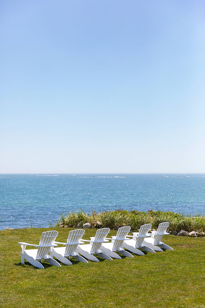 Row of Adirondack Chairs by the Coast in Summer landscape