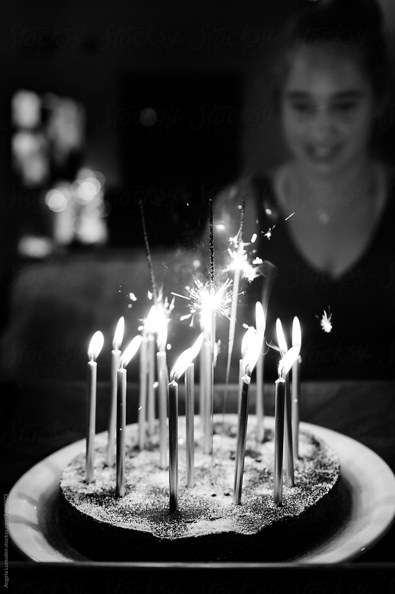 Teenage girl with a candle lit birthday cake