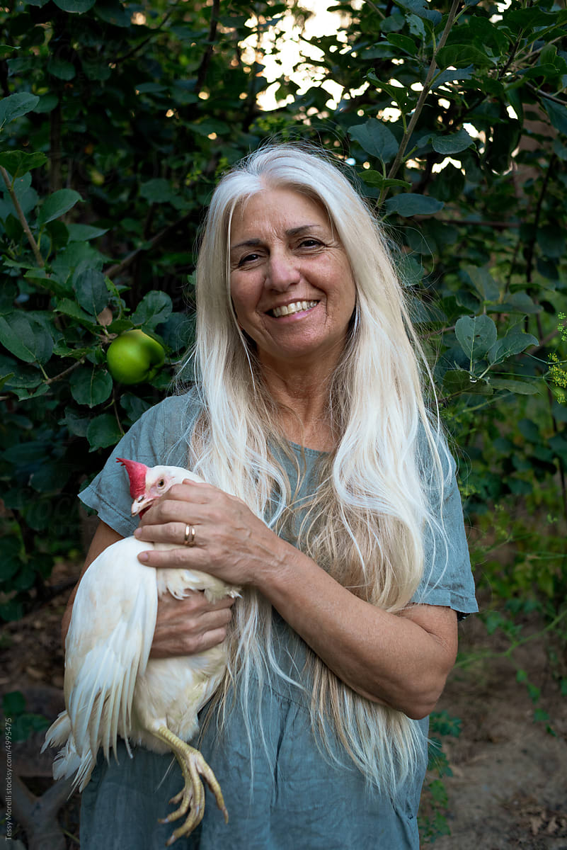 Happy mature woman and chicken portrait