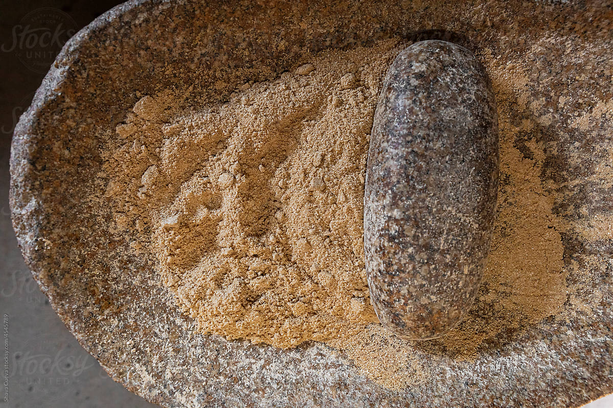 close up of a metate stone on ground corn powder