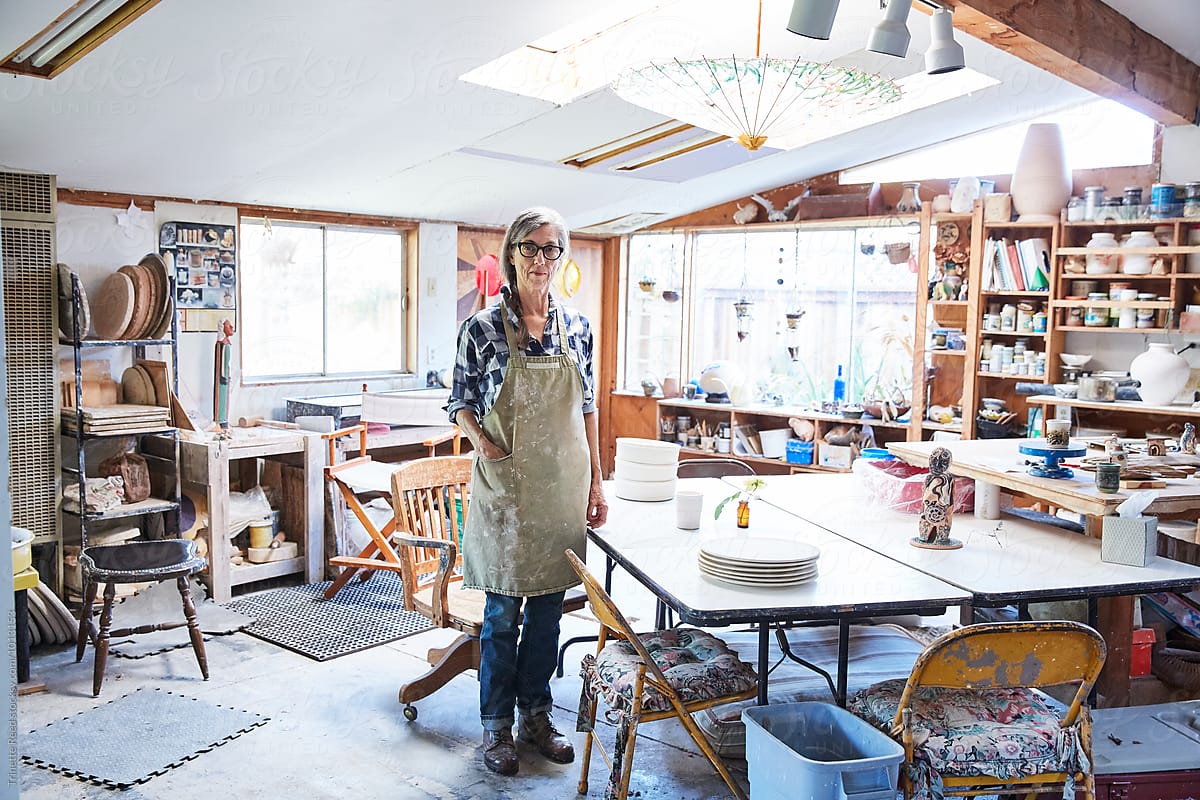 Portrait of senior woman with grey hair inside her pottery studio