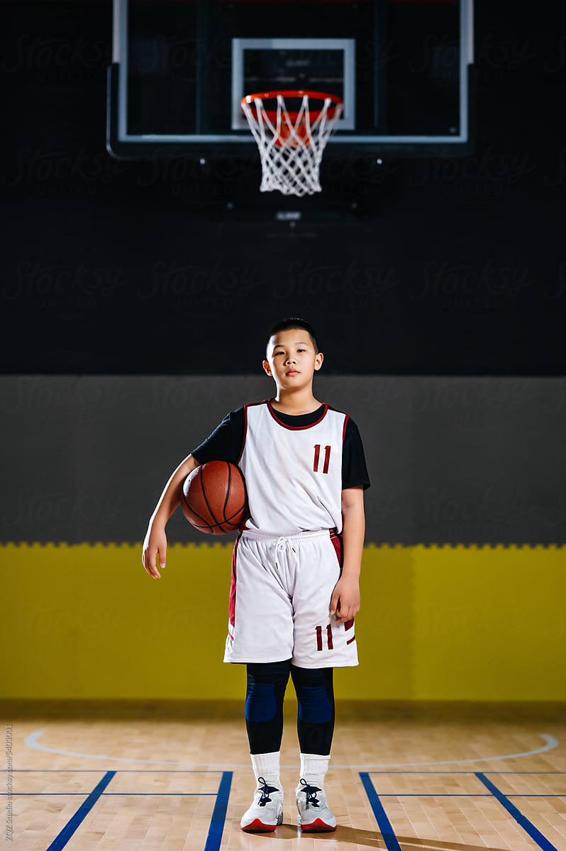 Portrait of basketball boy standing in a gym