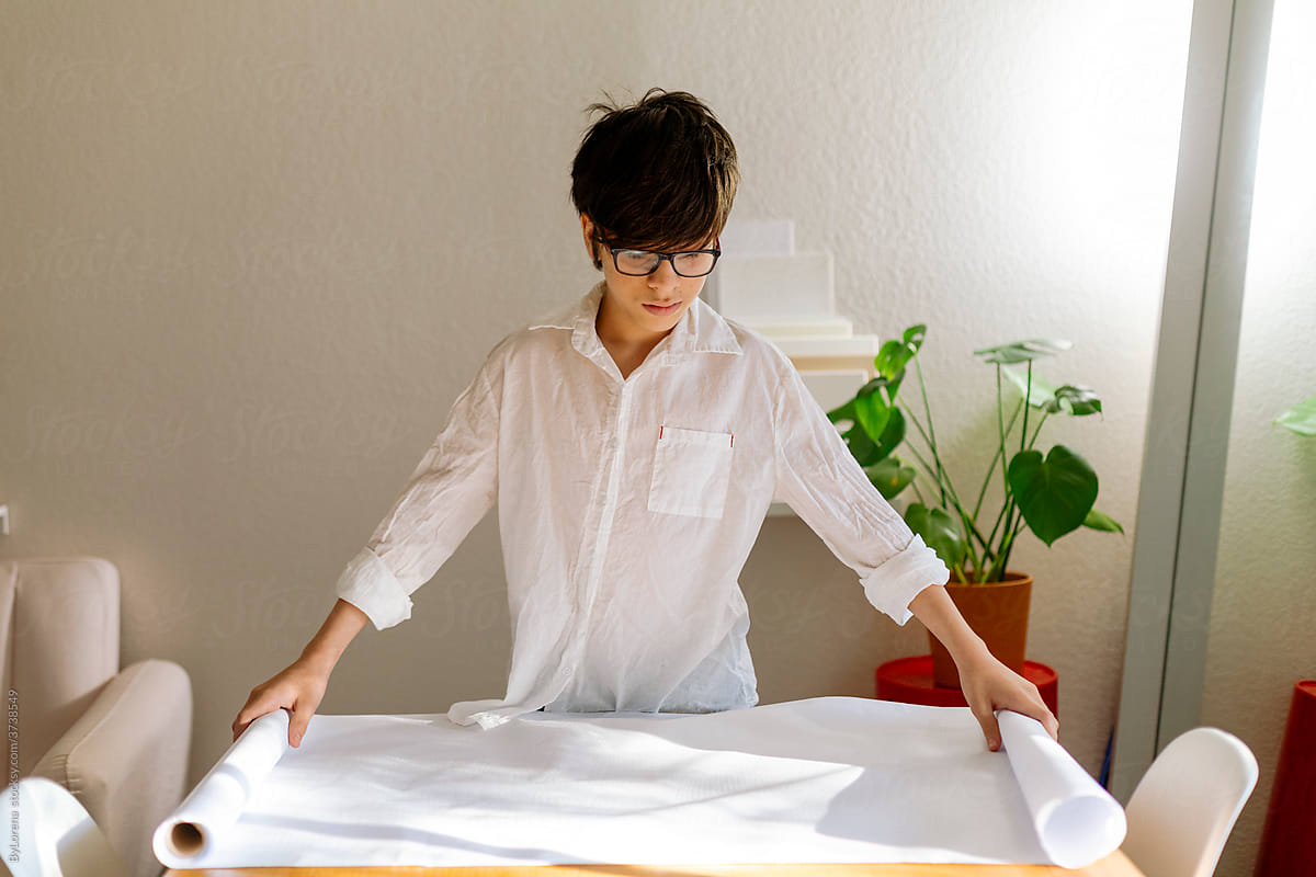 Young boy unrolling white roll paper