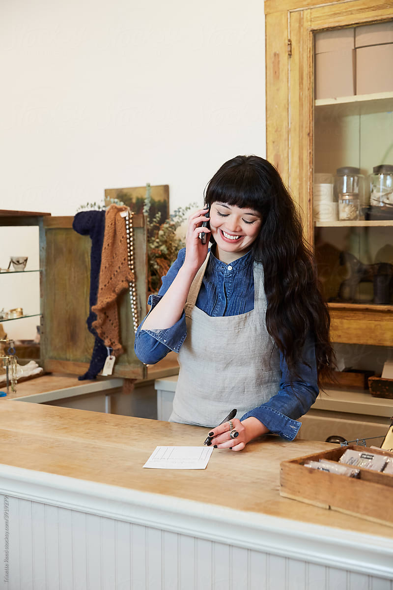 Woman taking an order over the phone and smiling