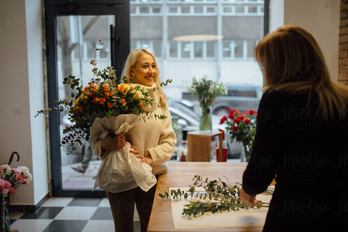 A Young Woman Buying A Flower Bouquet In A Flower Shop