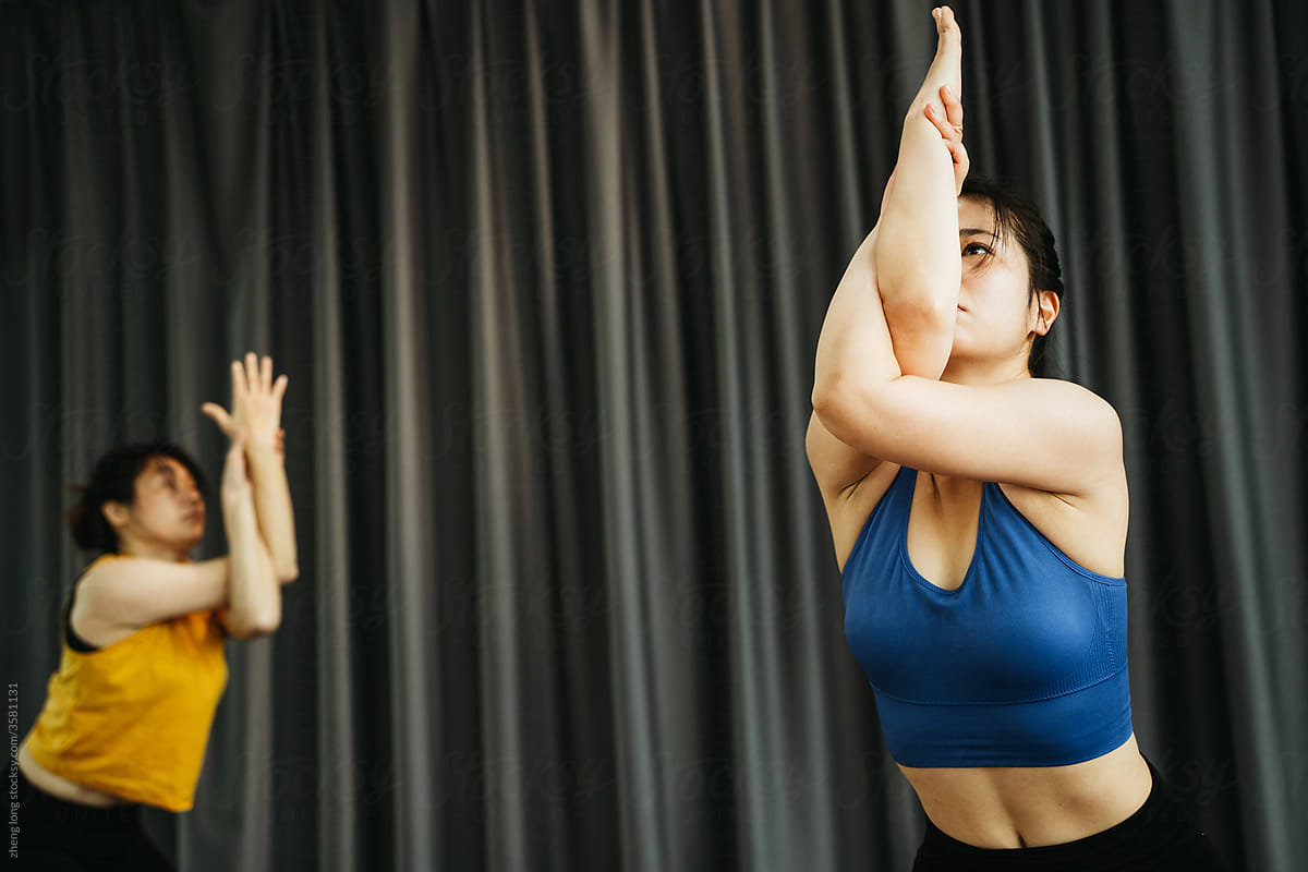 Young women practice yoga in a yoga studio