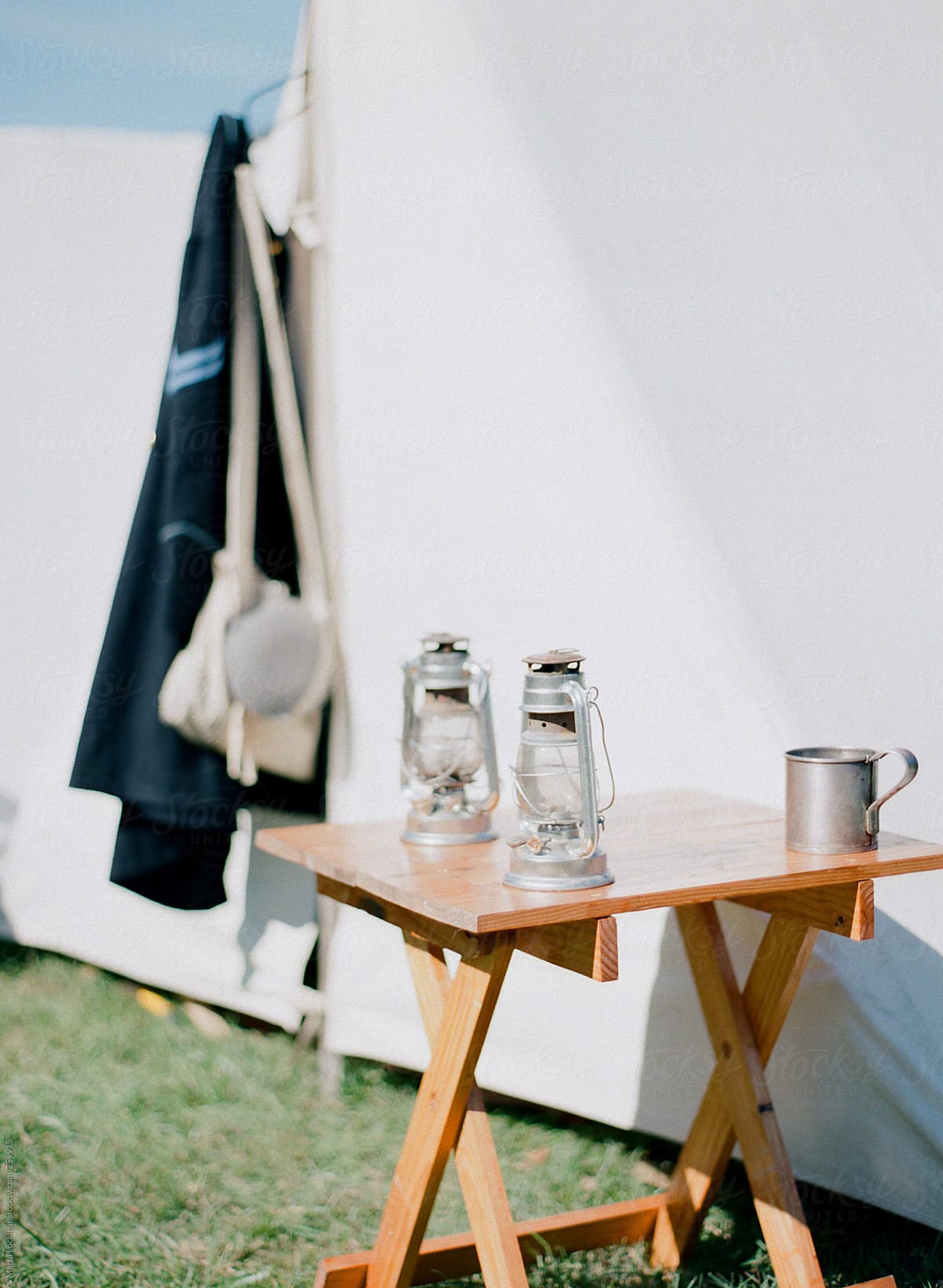 Old laterns with vintage jacket and canvas tent and wood table