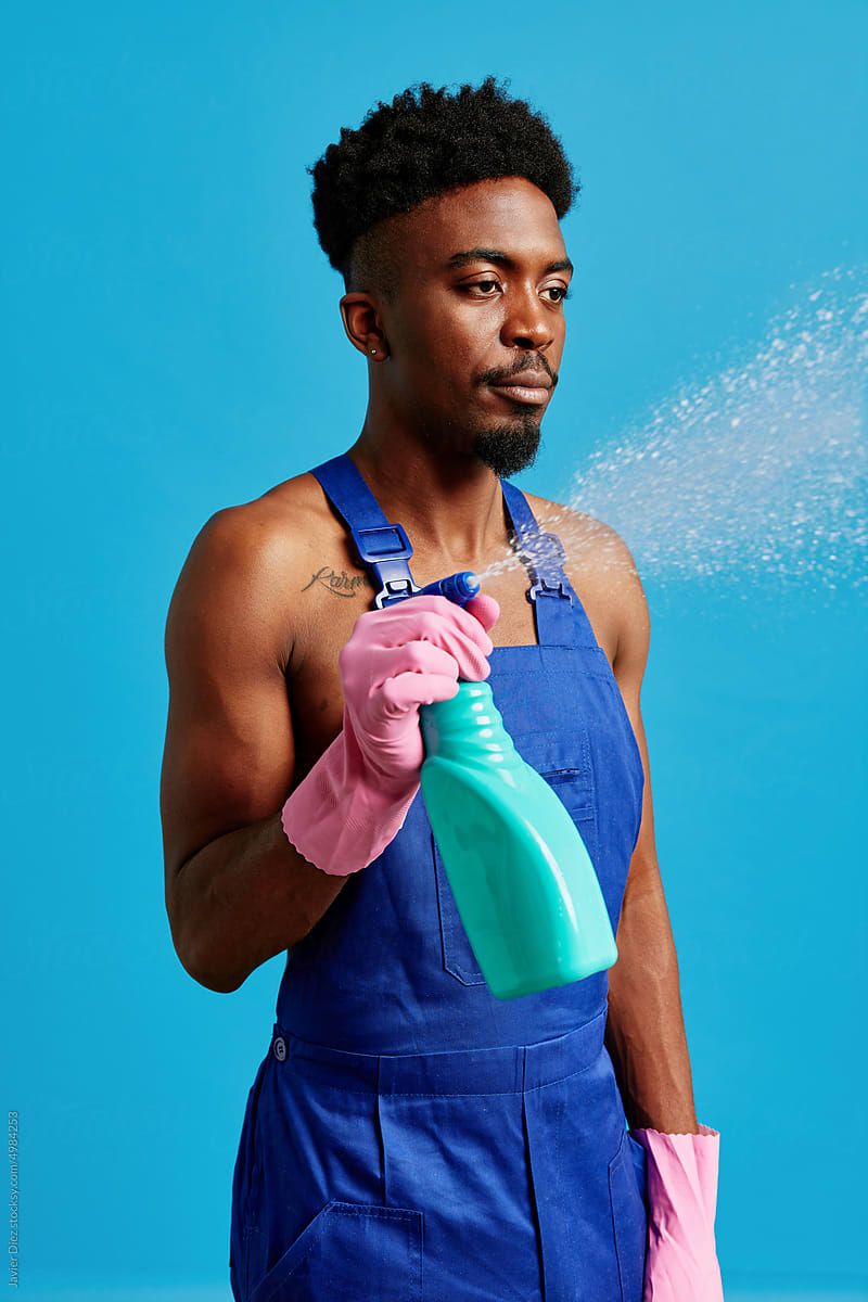 African American housekeeper spraying detergent