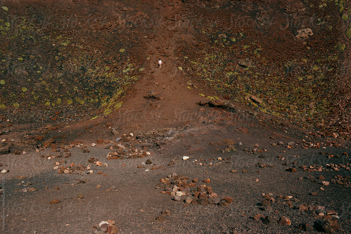 Tiny figure of person in volcanic landscape
